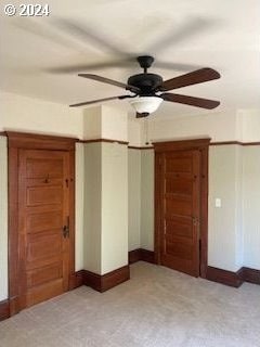 interior space with ceiling fan and light colored carpet