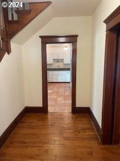 corridor with dark hardwood / wood-style flooring