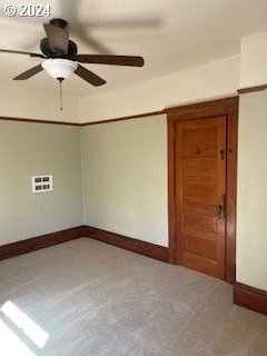 carpeted spare room featuring ceiling fan