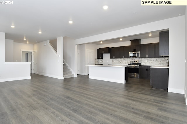 kitchen featuring stainless steel appliances, dark hardwood / wood-style floors, decorative backsplash, and a kitchen island