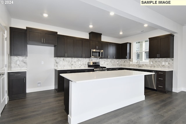 kitchen with sink, a kitchen island, backsplash, stainless steel appliances, and dark hardwood / wood-style floors