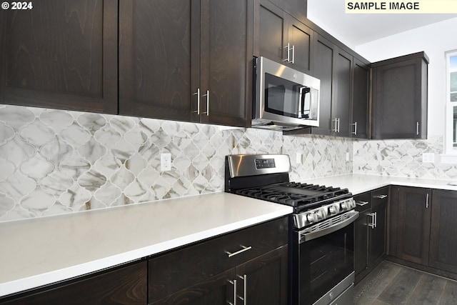 kitchen featuring dark brown cabinetry, stainless steel appliances, backsplash, and dark wood-type flooring