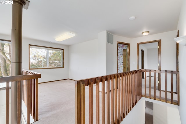 hallway featuring light colored carpet