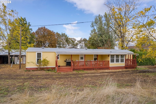 rear view of house with a wooden deck