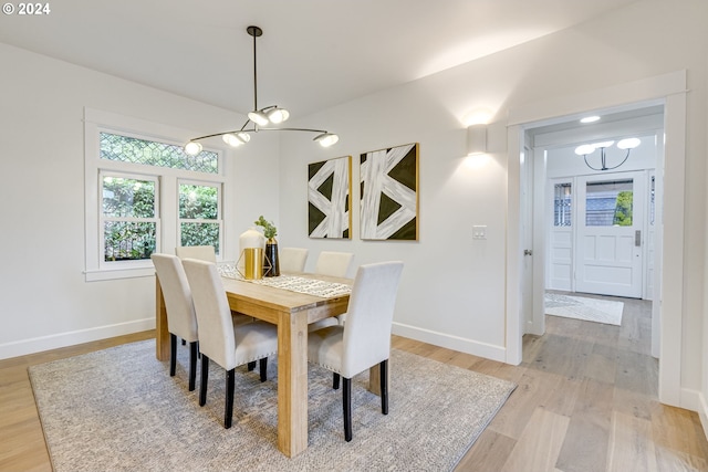 dining space with a notable chandelier and light hardwood / wood-style flooring