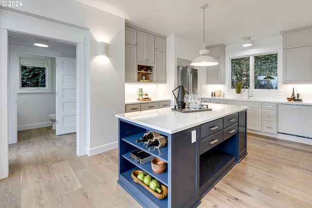 kitchen with hanging light fixtures, light hardwood / wood-style flooring, a kitchen island, decorative backsplash, and high end fridge