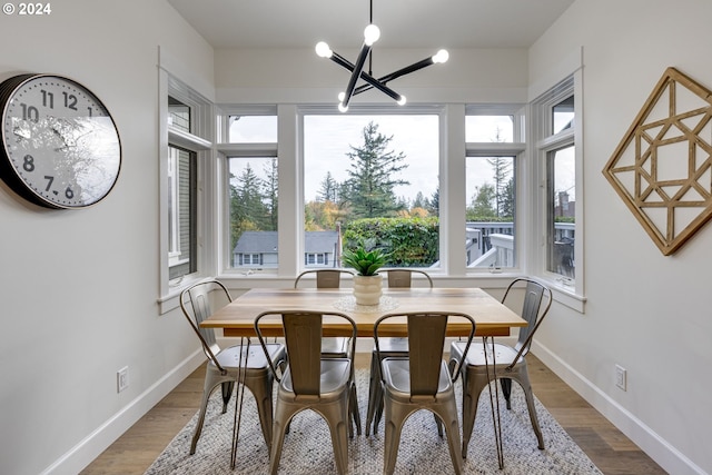 dining room with hardwood / wood-style flooring, plenty of natural light, and an inviting chandelier