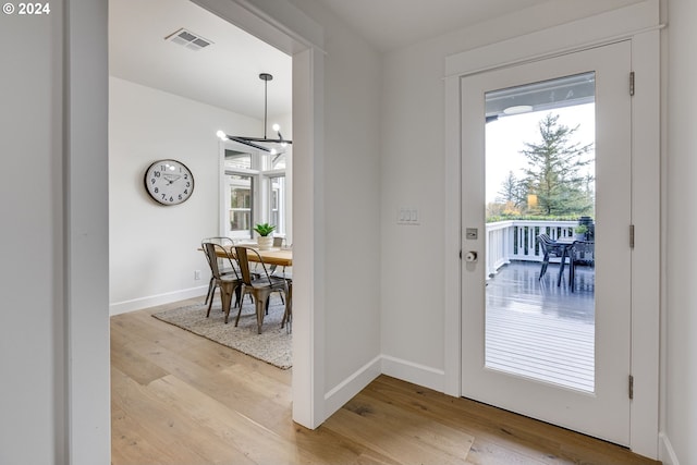 entryway with light hardwood / wood-style floors and a chandelier