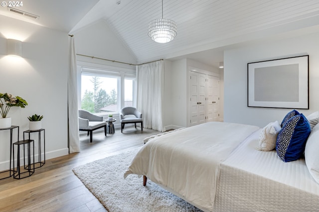 bedroom featuring wooden ceiling, a closet, light hardwood / wood-style flooring, and lofted ceiling