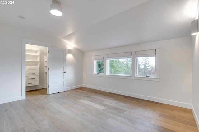 unfurnished bedroom featuring light hardwood / wood-style floors and vaulted ceiling