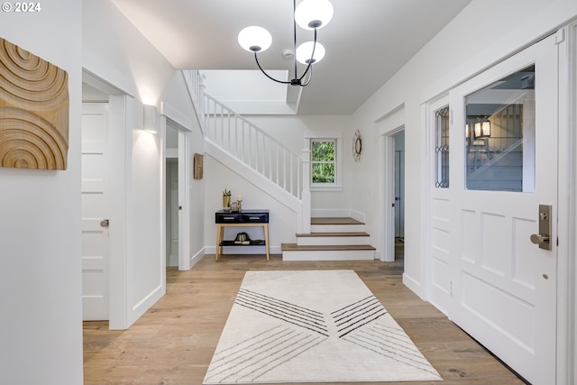 foyer entrance with a chandelier and light hardwood / wood-style flooring