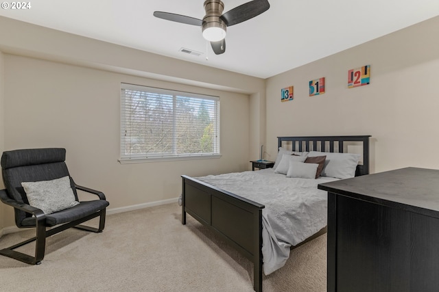 bedroom featuring a ceiling fan, light colored carpet, visible vents, and baseboards