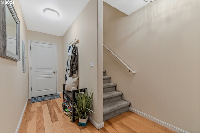 stairs with wood finished floors and baseboards