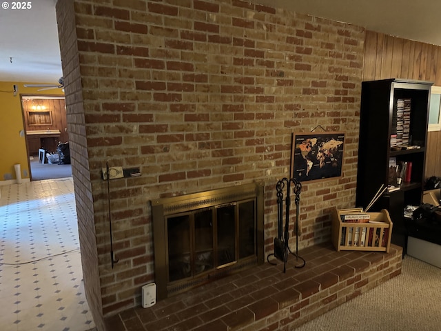 carpeted living room featuring a fireplace and wood walls