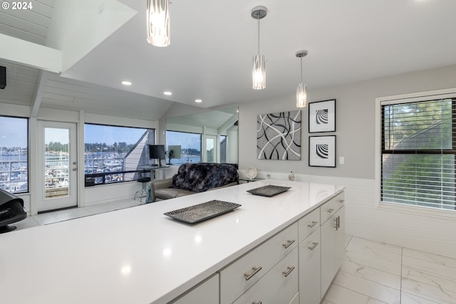 kitchen featuring white cabinetry, lofted ceiling, and pendant lighting