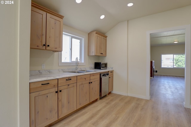 kitchen with appliances with stainless steel finishes, plenty of natural light, sink, and light wood-type flooring