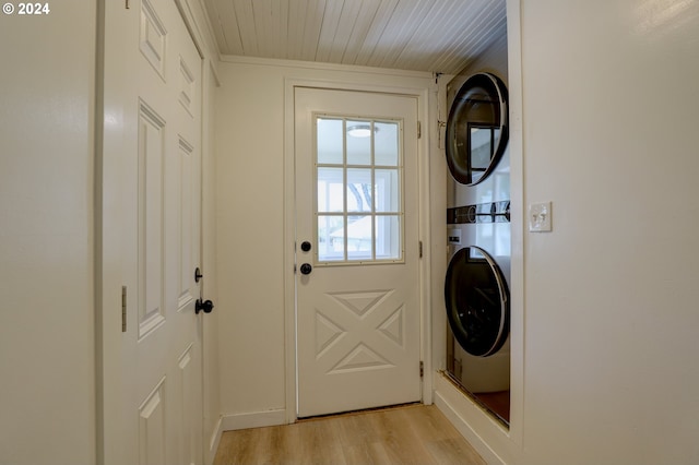 interior space with light hardwood / wood-style flooring and stacked washer / drying machine