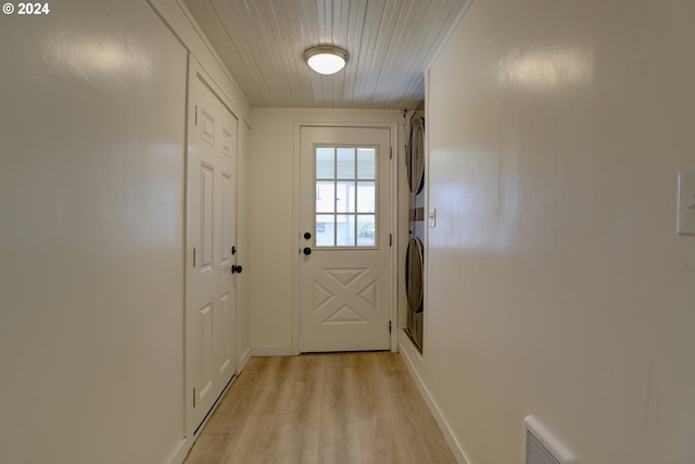 entryway featuring light hardwood / wood-style flooring, stacked washer / dryer, and ornamental molding