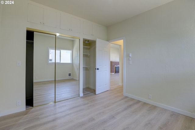 unfurnished bedroom featuring light hardwood / wood-style floors and a closet