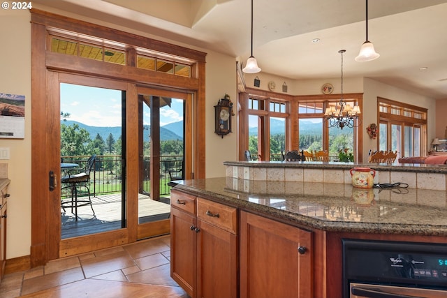 kitchen with a mountain view, dark stone counters, hanging light fixtures, and a chandelier