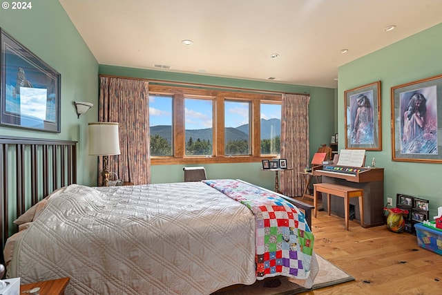 bedroom featuring light wood-type flooring and a mountain view