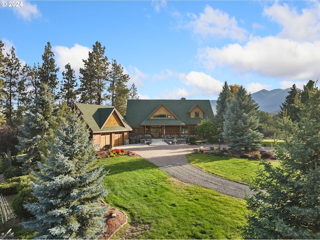 view of front of home with a mountain view and a front lawn