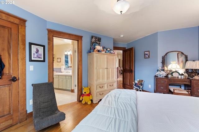 bedroom featuring light hardwood / wood-style flooring and ensuite bathroom