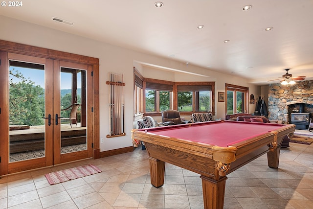 recreation room featuring a stone fireplace, plenty of natural light, and pool table