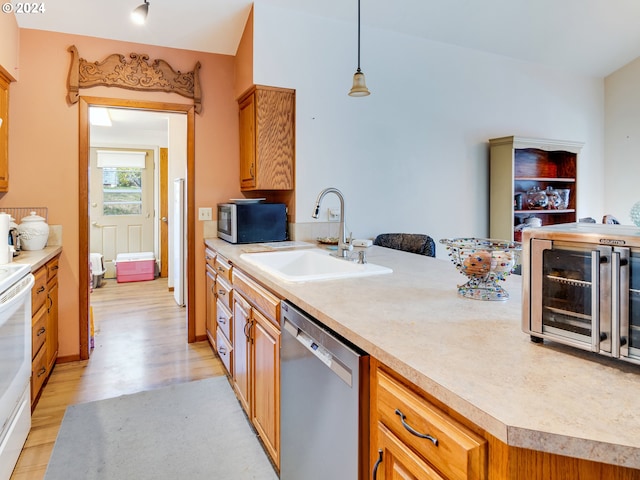 kitchen with pendant lighting, light wood-type flooring, sink, and appliances with stainless steel finishes