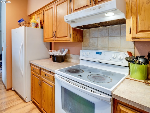 kitchen featuring tasteful backsplash, white appliances, and light hardwood / wood-style flooring