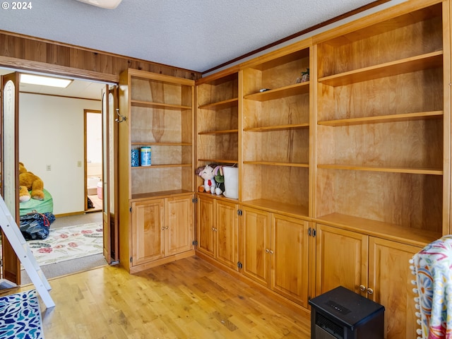 interior space with crown molding, wood-type flooring, and a textured ceiling