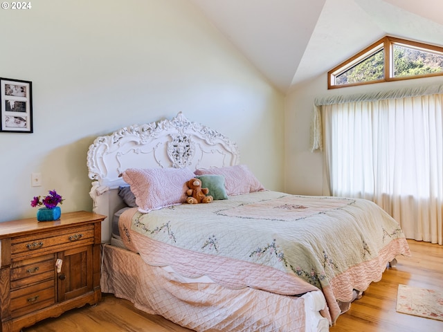 bedroom with vaulted ceiling and light wood-type flooring