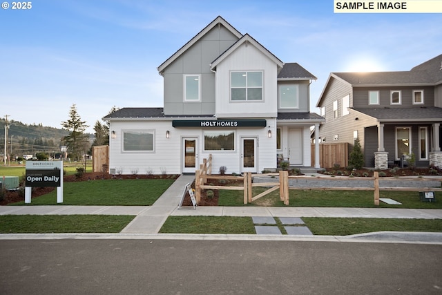 view of front of house featuring a front lawn, board and batten siding, and fence