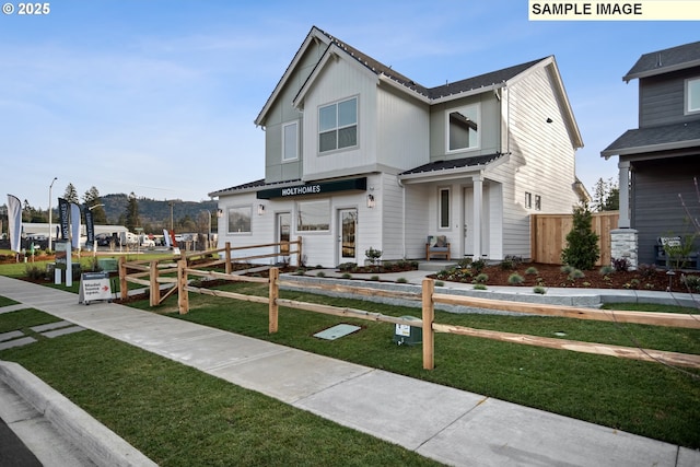 view of front facade featuring fence and a front lawn