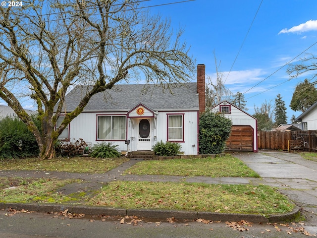 bungalow-style house featuring an outbuilding, a garage, and a front yard