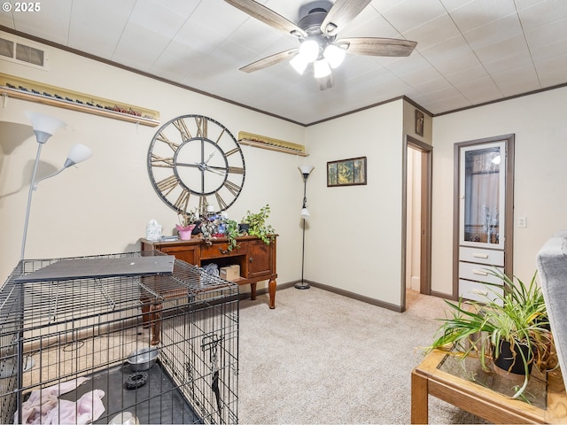 carpeted home office featuring ceiling fan and crown molding