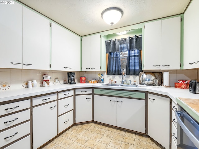 kitchen featuring tasteful backsplash, sink, white cabinets, and a textured ceiling