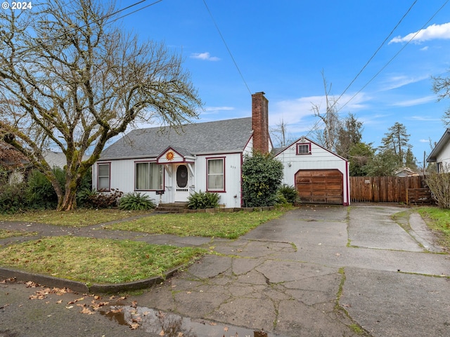 view of front of property featuring a garage, an outdoor structure, and a front yard