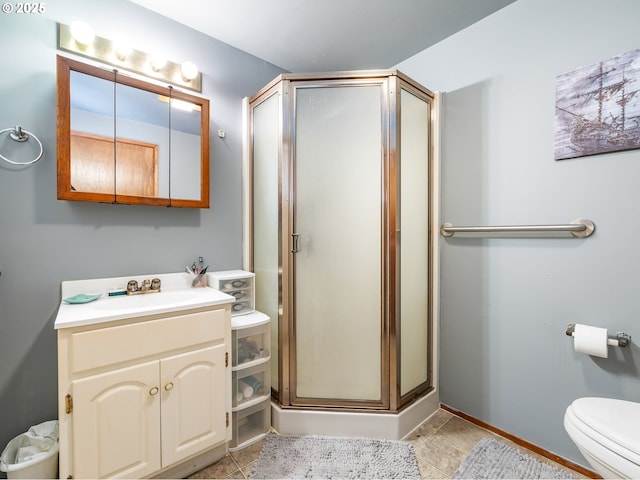 bathroom featuring tile patterned floors, vanity, toilet, and an enclosed shower