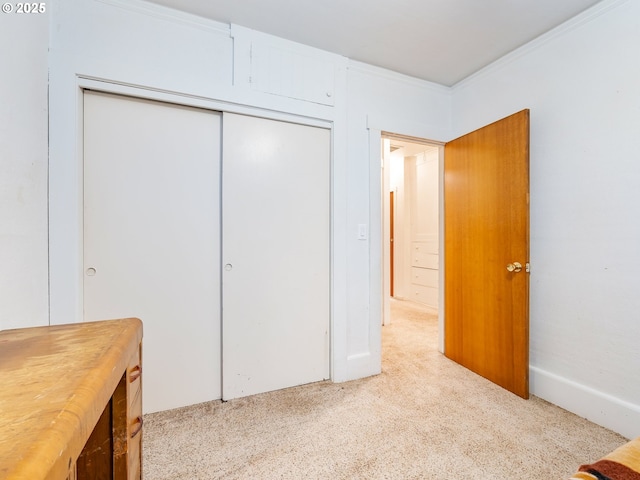 bedroom with light carpet, a closet, and crown molding