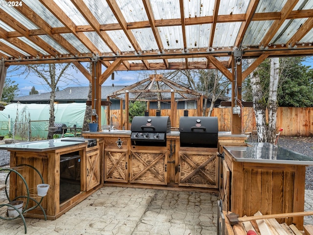 view of patio with a gazebo, grilling area, sink, and an outdoor kitchen