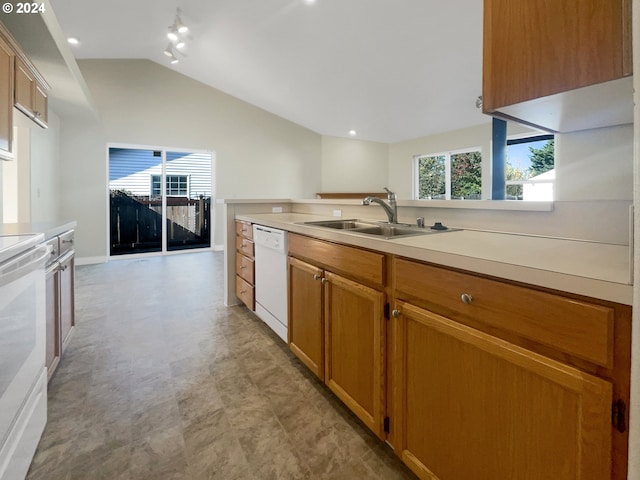 kitchen with lofted ceiling, white appliances, and sink