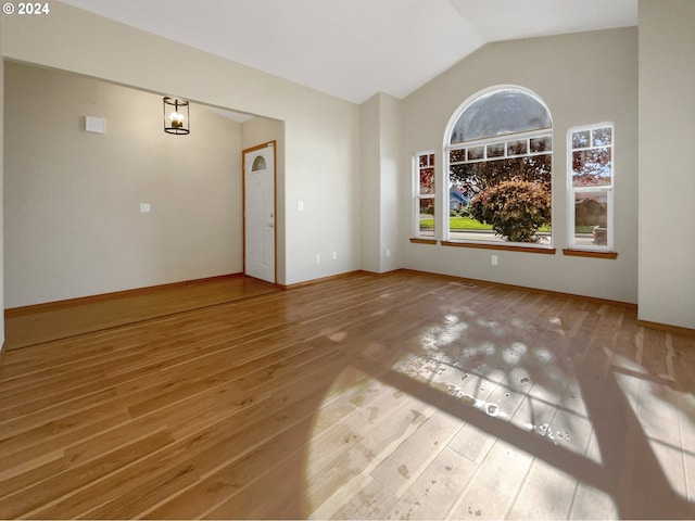 unfurnished room with vaulted ceiling and hardwood / wood-style flooring