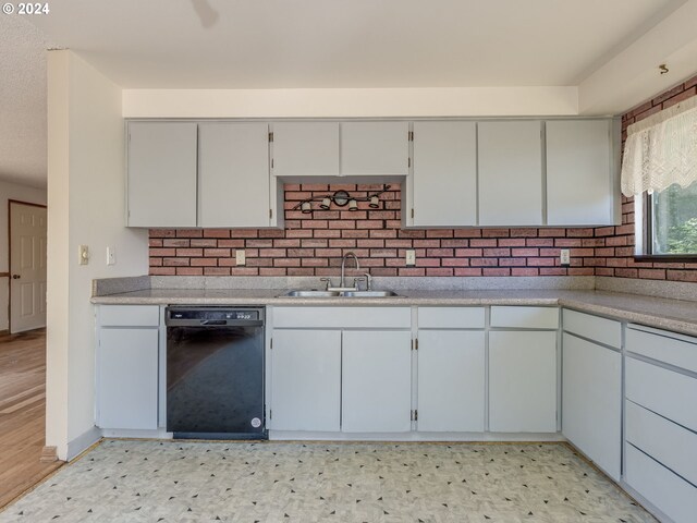 kitchen with black dishwasher, sink, light hardwood / wood-style flooring, and backsplash