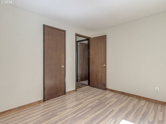 unfurnished bedroom featuring light hardwood / wood-style flooring and a textured ceiling