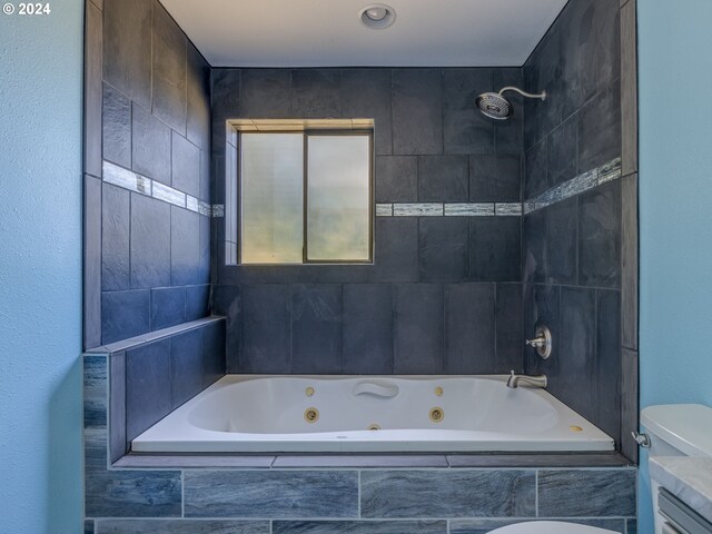 bathroom featuring toilet and tiled shower / bath