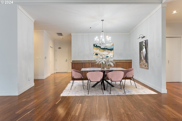 dining room with hardwood / wood-style floors, ornamental molding, and an inviting chandelier