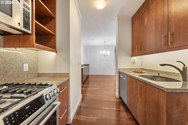 kitchen featuring appliances with stainless steel finishes, dark hardwood / wood-style flooring, sink, pendant lighting, and a notable chandelier