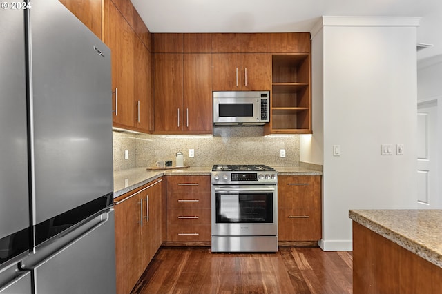 kitchen with tasteful backsplash, light stone countertops, dark wood-type flooring, and stainless steel appliances