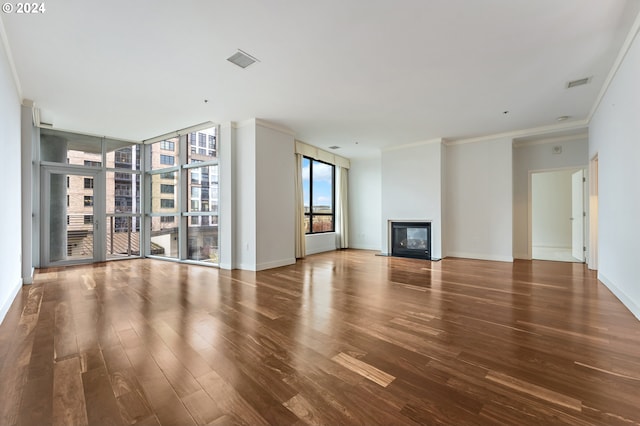 unfurnished living room with crown molding and hardwood / wood-style flooring